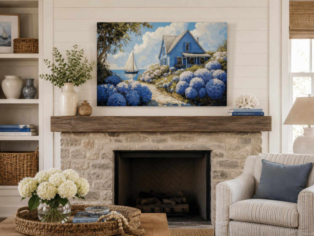 Coastal canvas print of a blue cottage and sailboat scene above a stone fireplace.