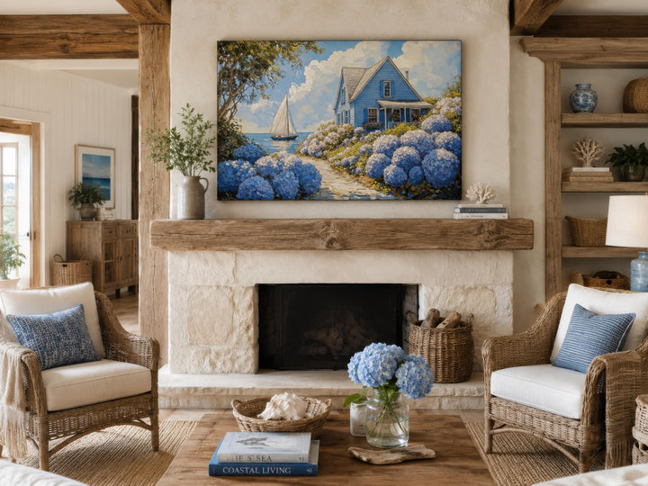 Coastal canvas print of a blue cottage and sailboat above a rustic stone fireplace.