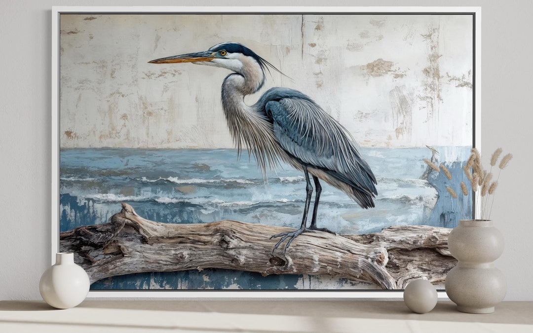 Coastal heron on driftwood canvas wall art in a white frame with a weathered, serene aesthetic.