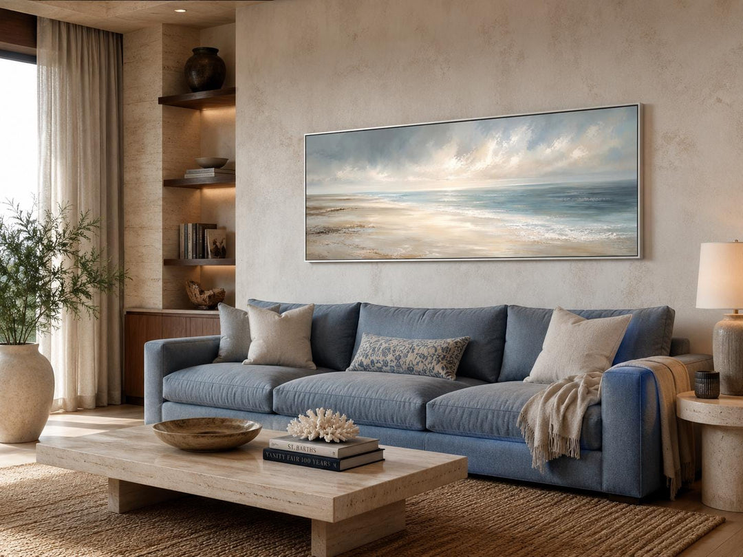 Long horizontal coastal wall art canvas featuring a soft ocean seascape above a blue sofa.