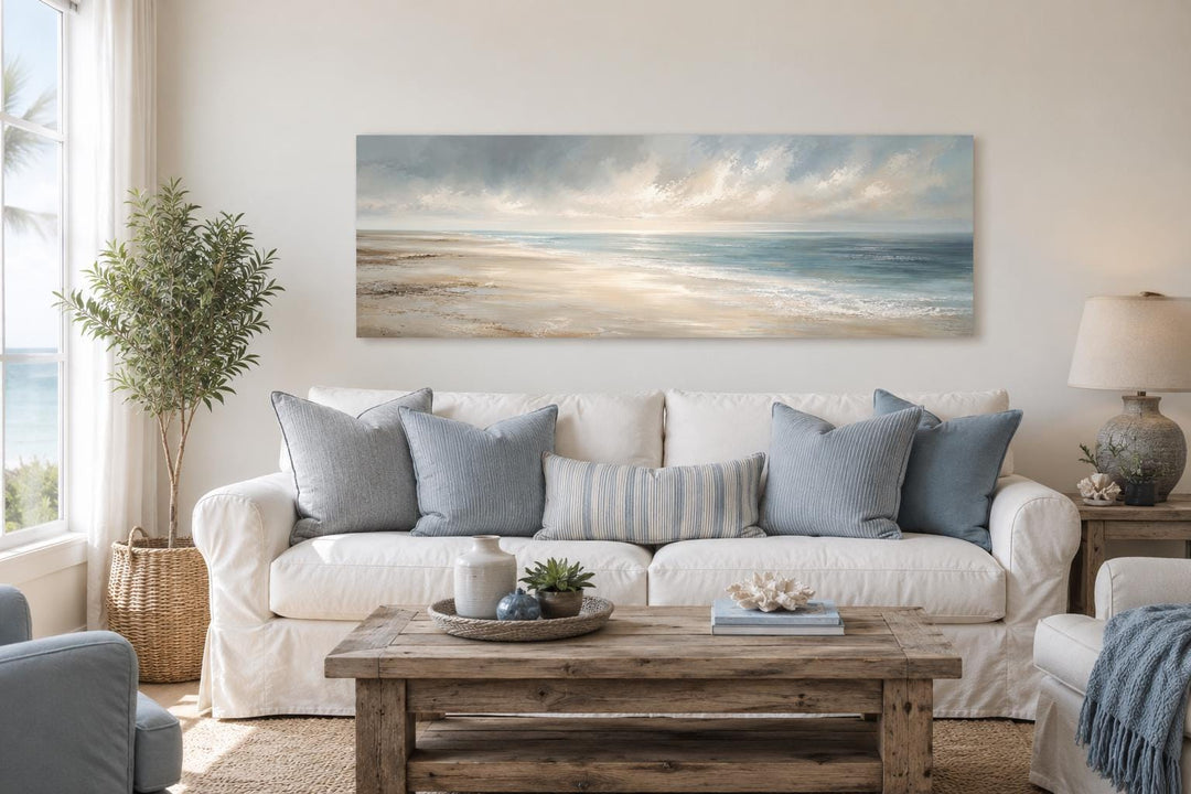 Long horizontal coastal wall art canvas featuring a soft ocean seascape above a white sofa.