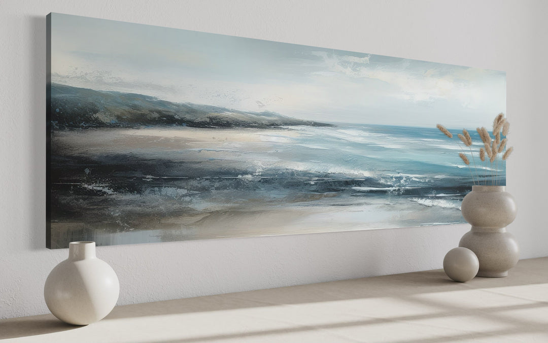 Long narrow coastal canvas wall art featuring a serene blue ocean and sandy beach scene.
