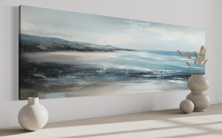 Long narrow coastal canvas wall art featuring a serene blue ocean and sandy beach scene.