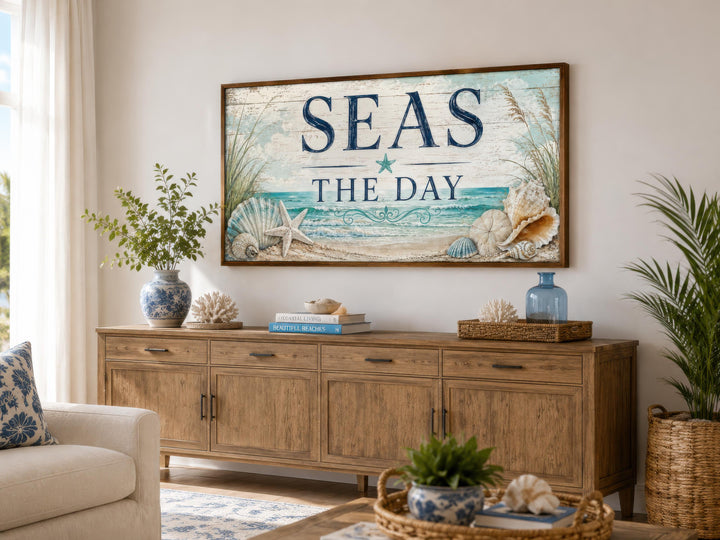 Coastal wall art with "Seas the Day" text, starfish, and shells above a wooden sideboard.
