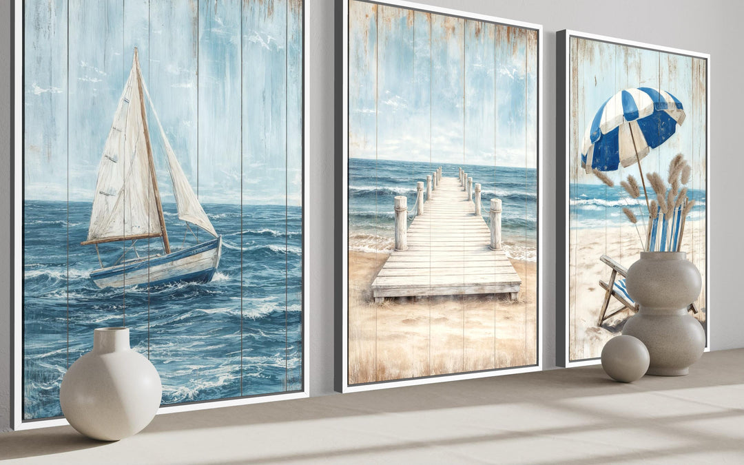 Three-piece coastal wall art set featuring a sailboat, a wooden pier, and a beach umbrella.