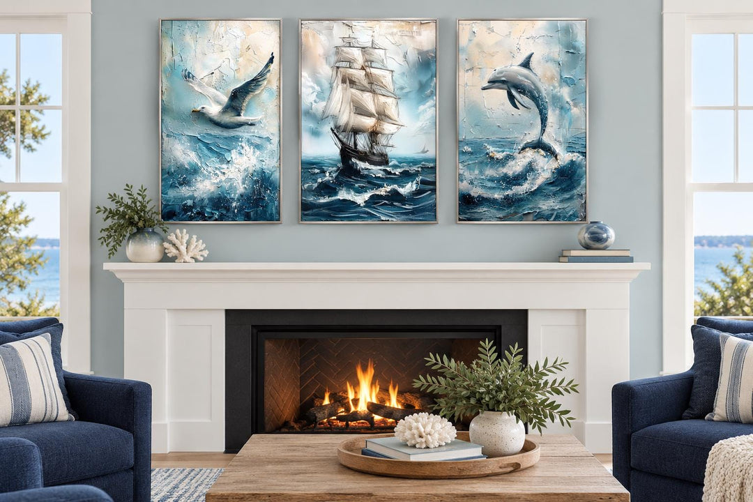 Set of 3 coastal canvas prints featuring a seagull, sailing ship, and dolphin above a fireplace.
