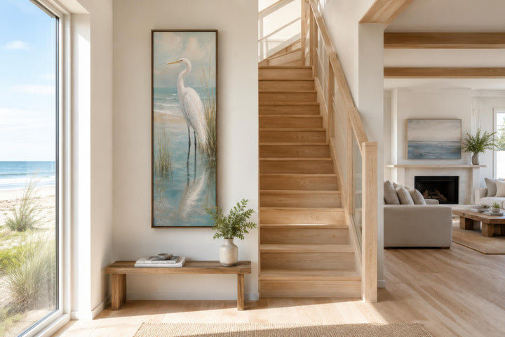 Tall narrow vertical canvas print of a white egret in teal coastal water on a beach house wall.