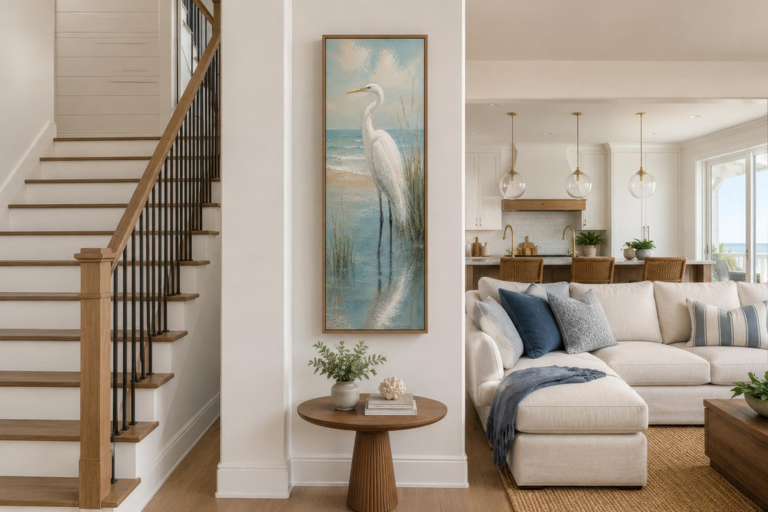 Tall narrow vertical canvas print of a white egret in teal coastal water on a white wall.