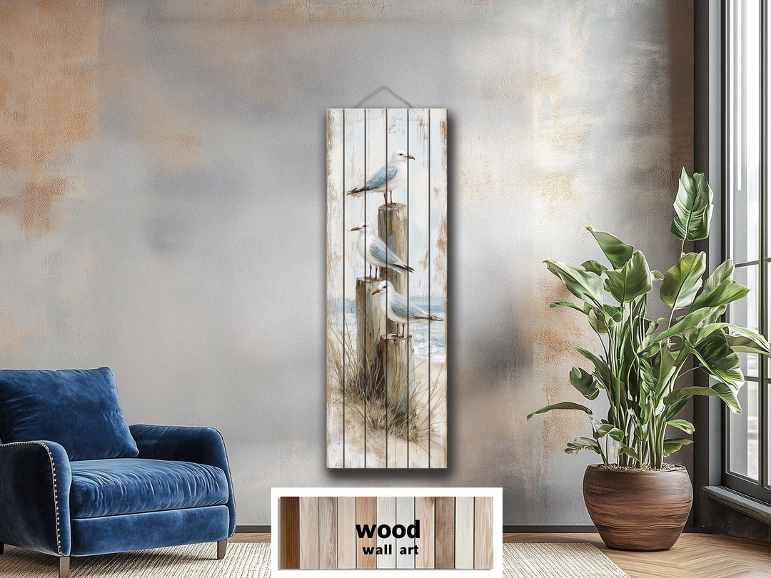 Tall narrow coastal wood wall art featuring seagulls perched on posts in a distressed beach scene.