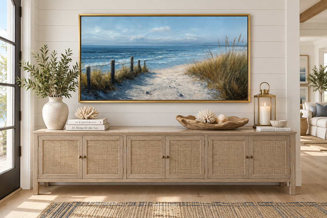 Horizontal coastal beach canvas print with a sandy path and blue ocean above a wooden sideboard.
