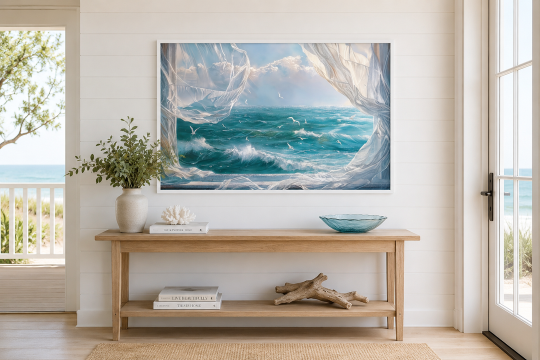 Ocean view framed canvas wall art with seagulls and white curtains above a wooden console table.