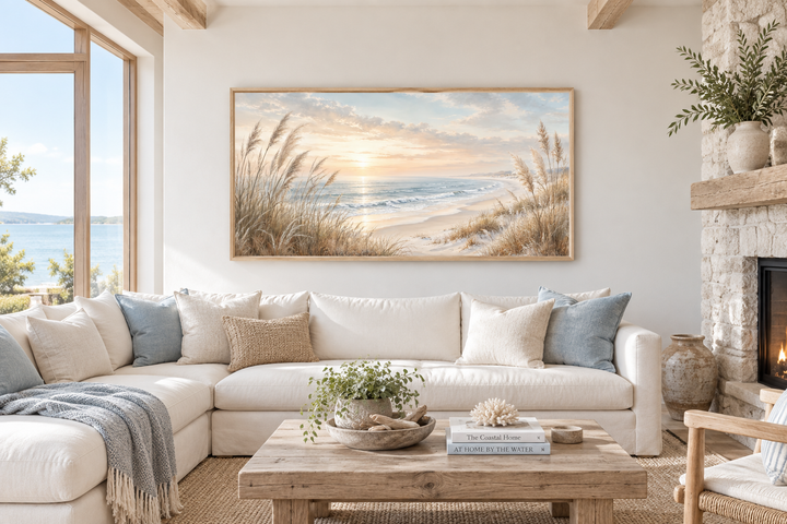 Framed beach pampas grass canvas art above a white sectional sofa in a coastal living room.