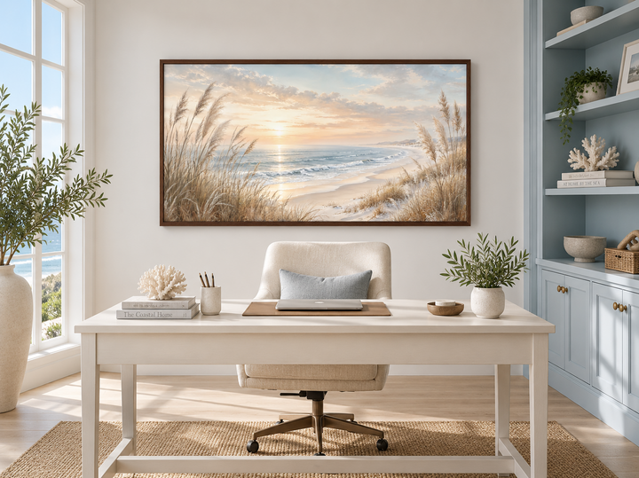 Framed coastal canvas print of beach pampas grass at sunset above a white desk in a home office.
