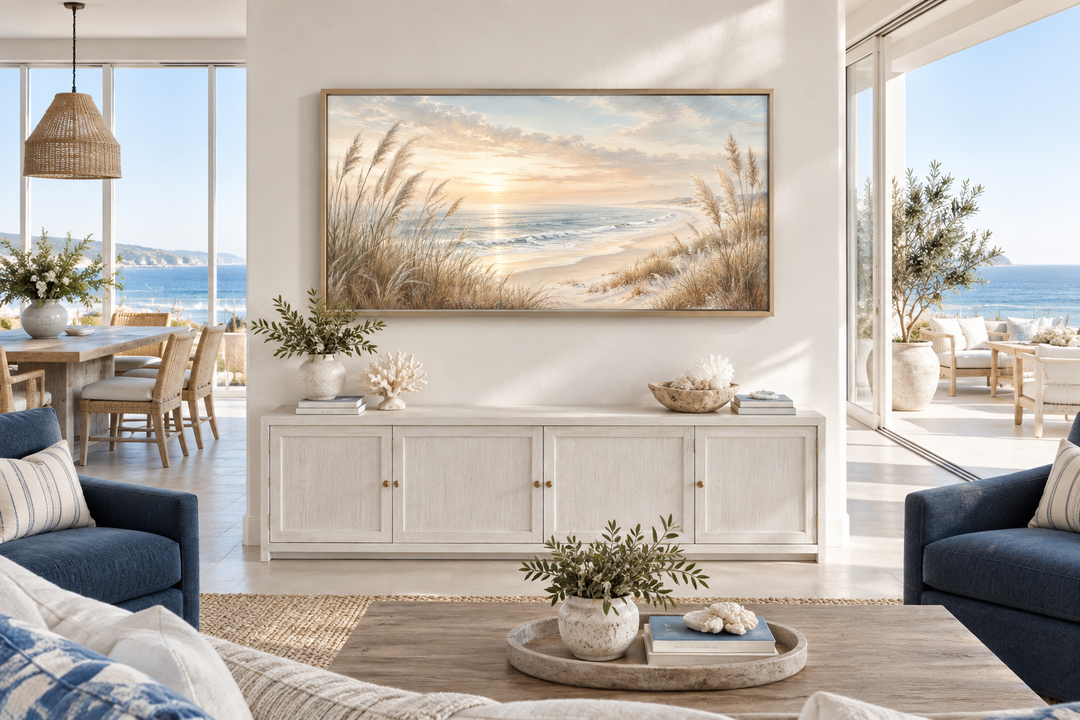 Framed coastal canvas print of beach pampas grass at sunset above a white sideboard.