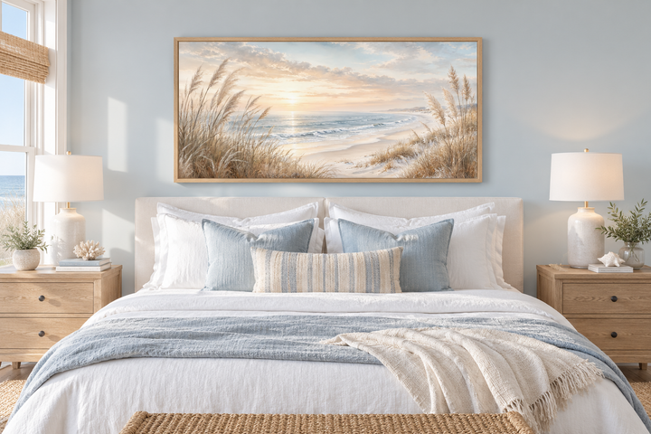 Framed beach pampas grass canvas art hanging above a bed in a neutral coastal bedroom.