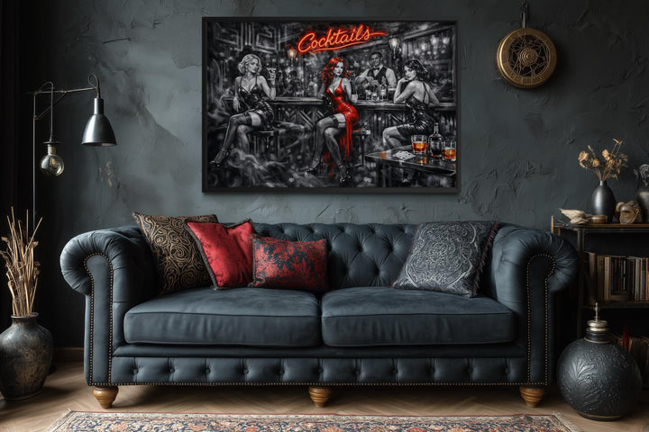 A cinematic noir canvas print of a cocktail bar scene hangs above a dark tufted leather sofa.