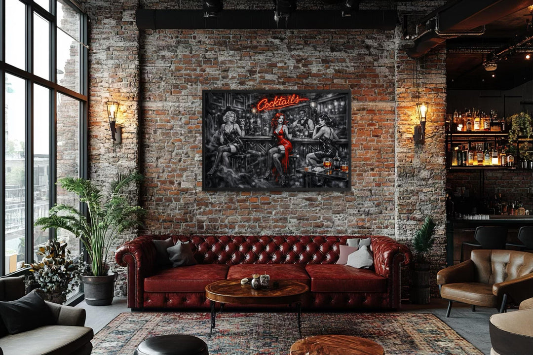 A framed noir-style canvas print of a cocktail bar with selective red accents hangs in a loft.