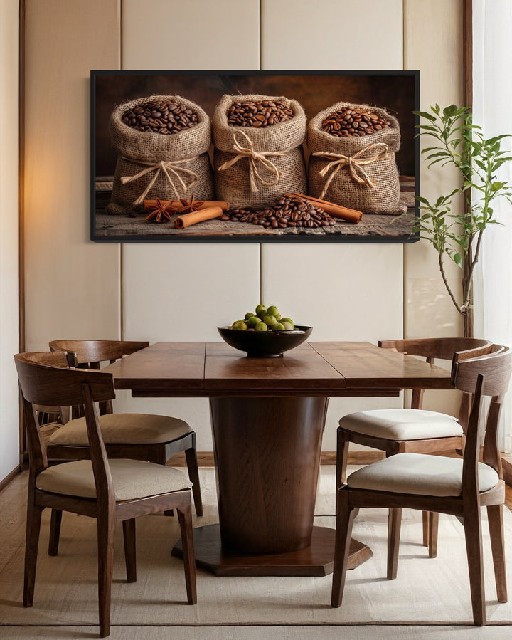 Framed canvas wall art of coffee beans in burlap bags and cinnamon sticks above a dining table.