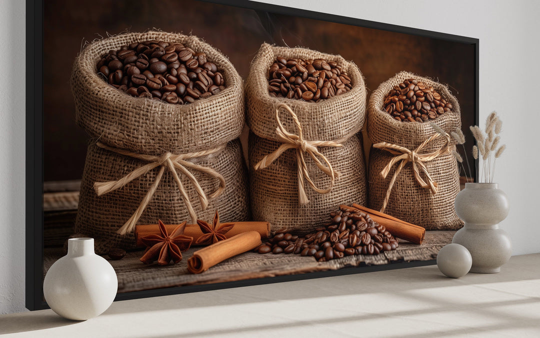 Framed canvas wall art of coffee beans in burlap bags with cinnamon sticks and star anise.