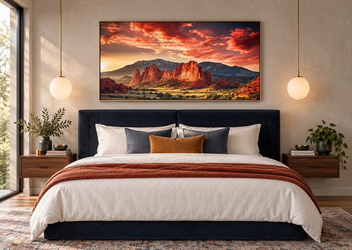 Framed canvas wall art of Garden of the Gods and Pikes Peak at sunset above a navy blue bed.