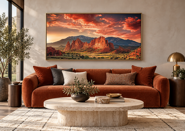 Framed canvas wall art of Garden of the Gods and Pikes Peak at sunset above a rust-colored sofa.