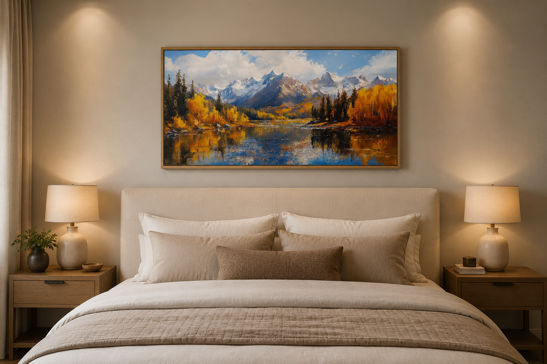 Framed canvas painting of Colorado Rocky Mountains in autumn above a bed in a neutral bedroom.