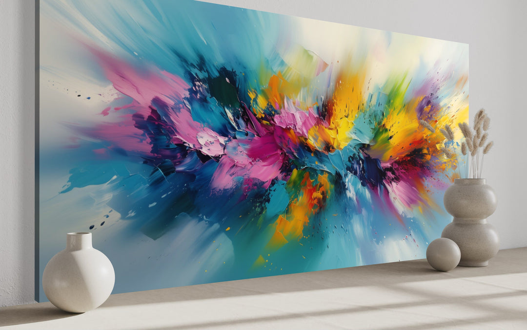 Large abstract wall art with vibrant blue, pink, and yellow brushstrokes in a modern living room.