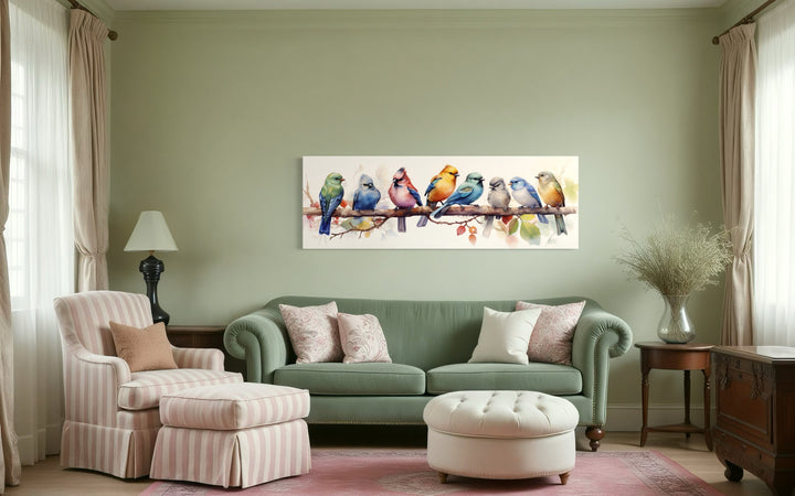 Colorful Birds On A Branch Horizontal Framed Canvas Wall Art displayed above a green sofa.