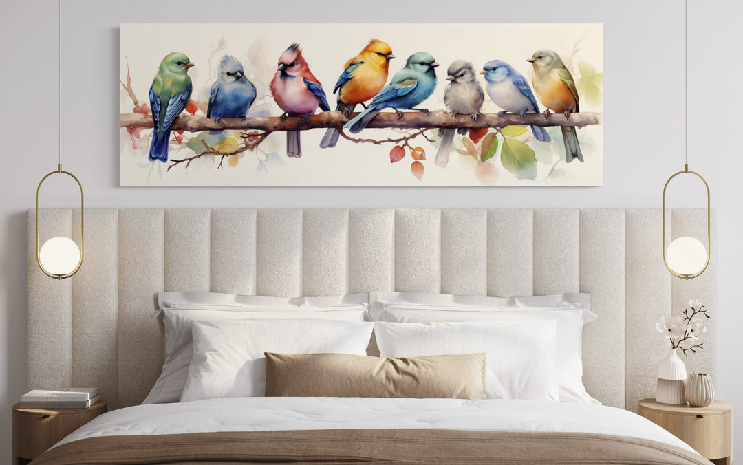 Horizontal framed canvas wall art of eight colorful birds perched on a branch above a bed.