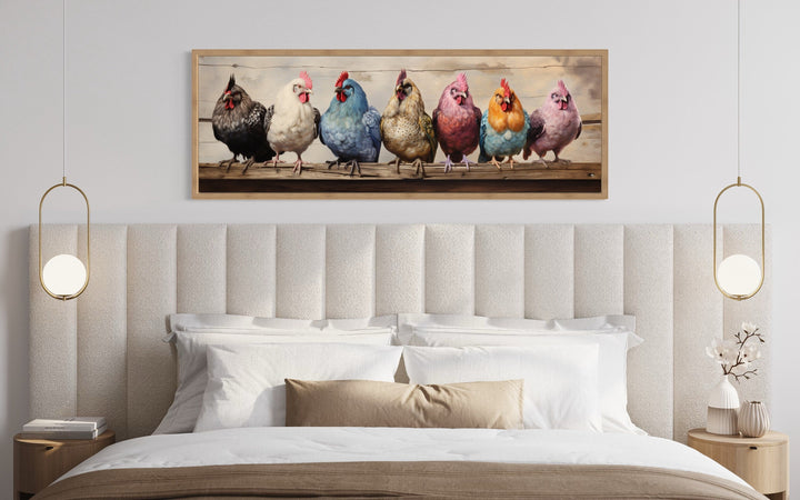 Panoramic farmhouse wall art of colorful chickens on a fence above a modern bed with gold lamps.
