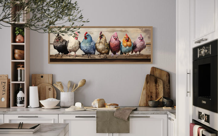 Panoramic framed canvas wall art of seven colorful chickens perched on a rustic wooden fence.