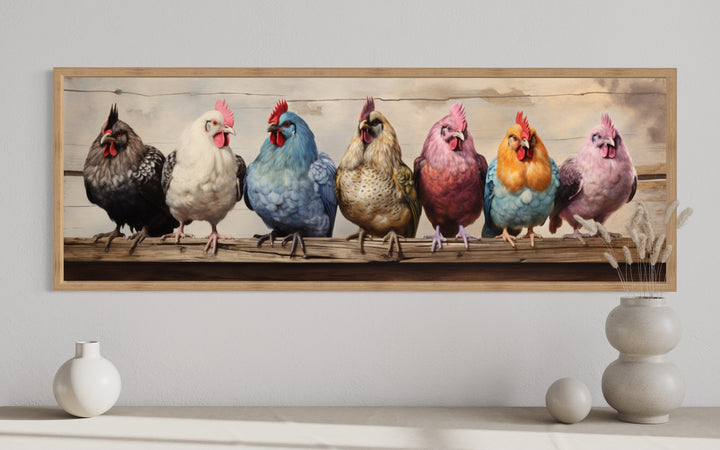 Panoramic framed canvas art of seven colorful chickens perched on a rustic wooden fence.