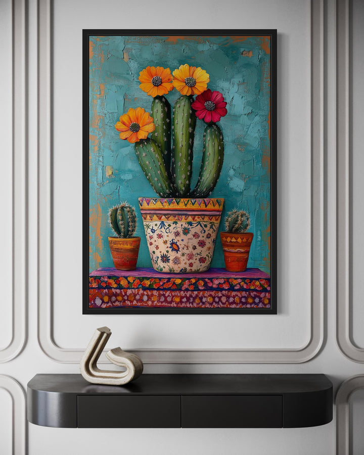 Colorful Mexican blooming cactus framed canvas wall art above a black console table.