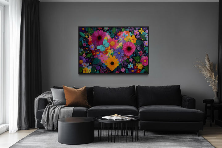 Colorful floral heart wall art with butterflies on a gray wall above a black sofa in a living room.