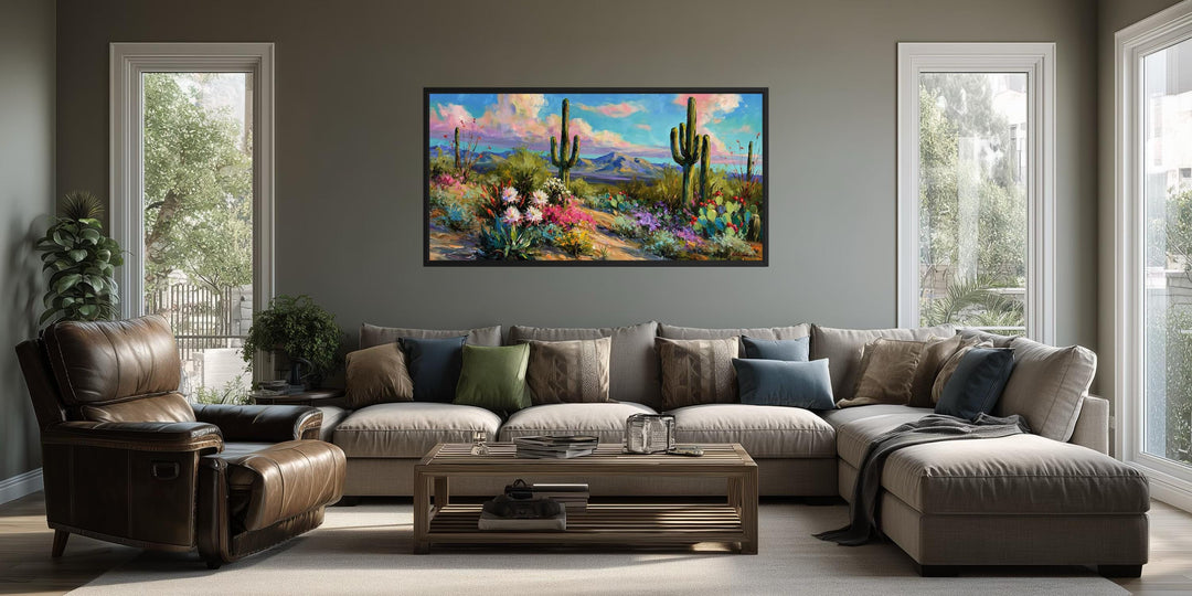 Colorful saguaro cactus and wildflower desert canvas wall art displayed above a living room sofa.