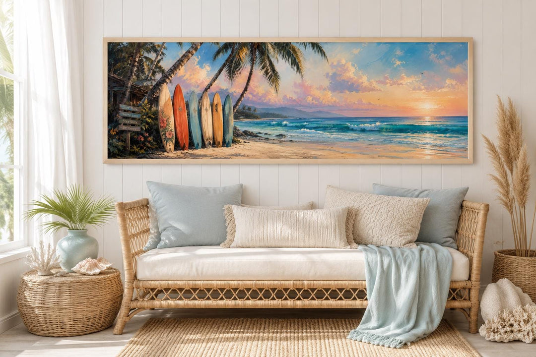 Horizontal canvas wall art of colorful surfboards on a tropical beach at sunset above a sofa.