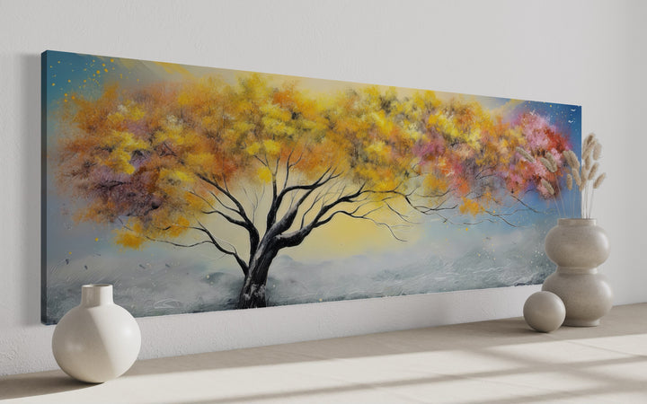 Horizontal framed canvas wall art featuring a vibrant yellow, orange, and pink tree over mountains.