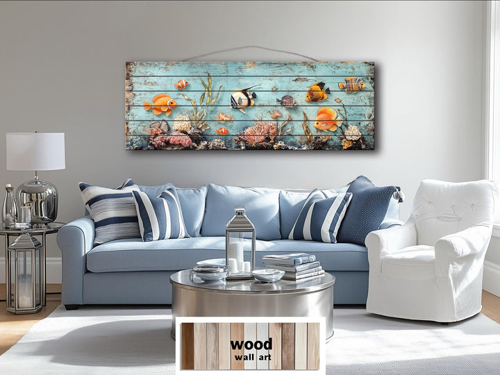 A long, narrow distressed wood wall art piece featuring colorful tropical fish and a coral reef.