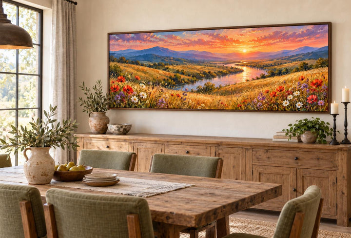Panoramic canvas art of a wildflower meadow and river at sunset above a wooden sideboard.
