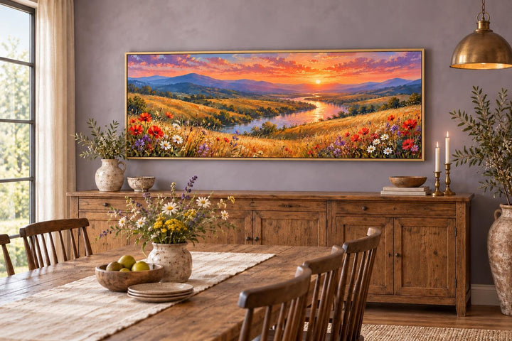 Panoramic canvas art of a wildflower meadow and river at sunset above a wooden sideboard.