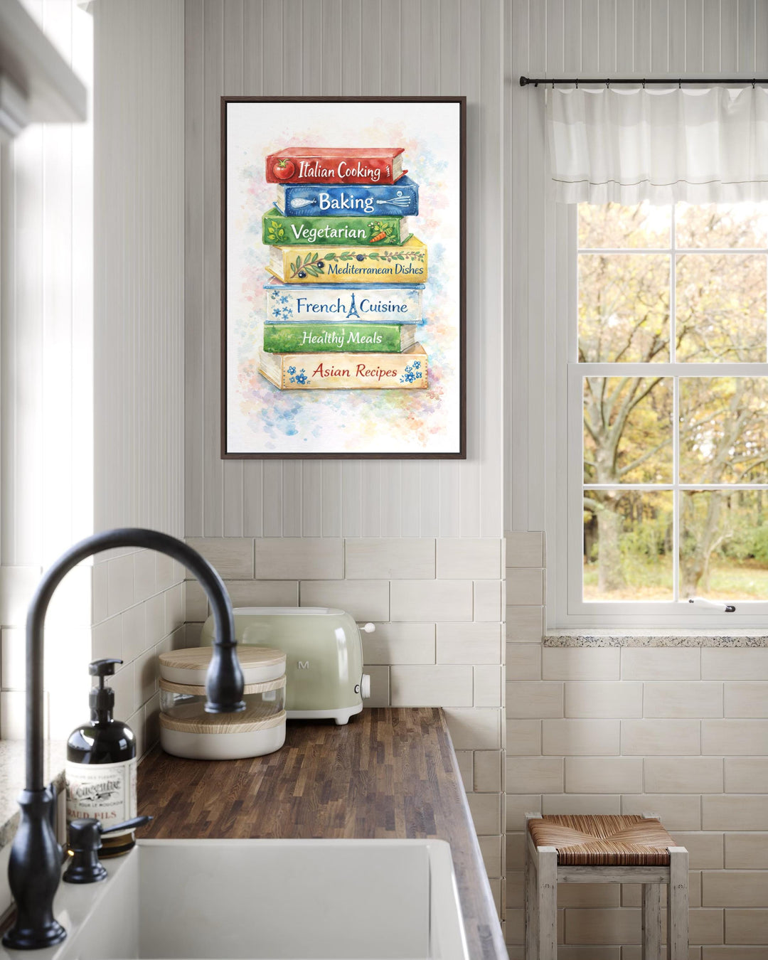A vertical canvas print of colorful stacked cookbooks hangs in a bright farmhouse kitchen.