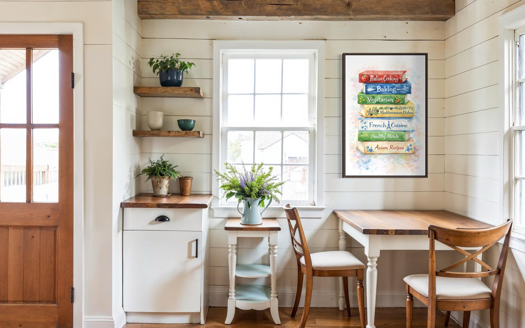 A vertical canvas print of colorful stacked cookbooks hangs in a bright farmhouse kitchen nook.