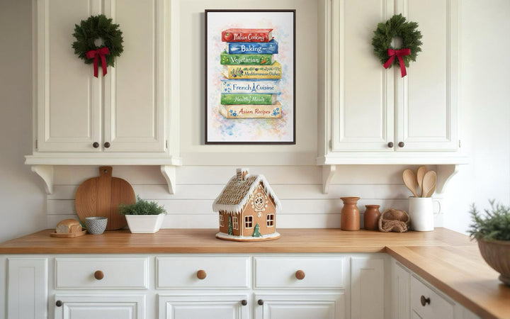 A vertical canvas print of stacked colorful cookbooks hangs in a bright farmhouse kitchen.