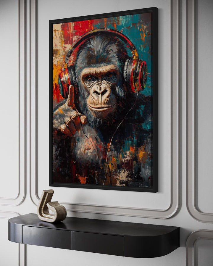 Cool DJ gorilla with red headphones canvas wall art in a black frame on a white paneled wall.