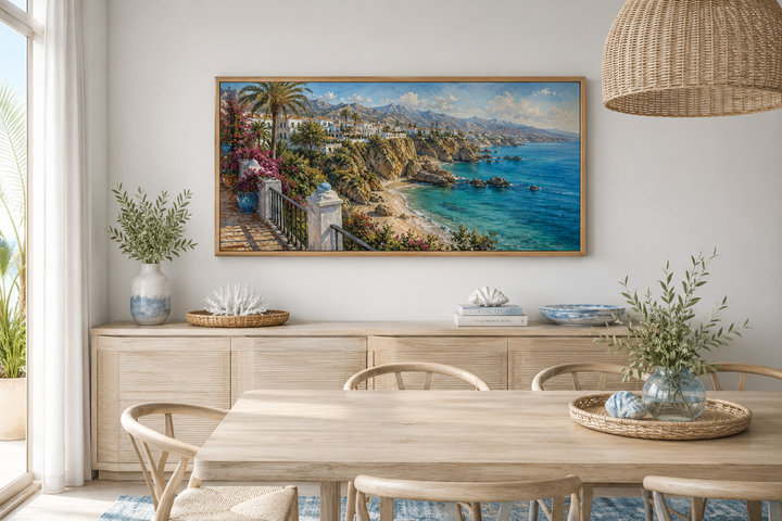 Framed canvas wall art of a Mediterranean coastal village above a dining table and sideboard.