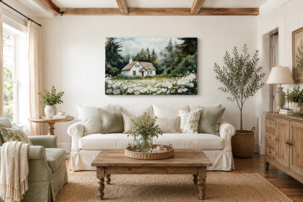 A large canvas print of a white cottage in a daisy field hangs in a cozy farmhouse living room.