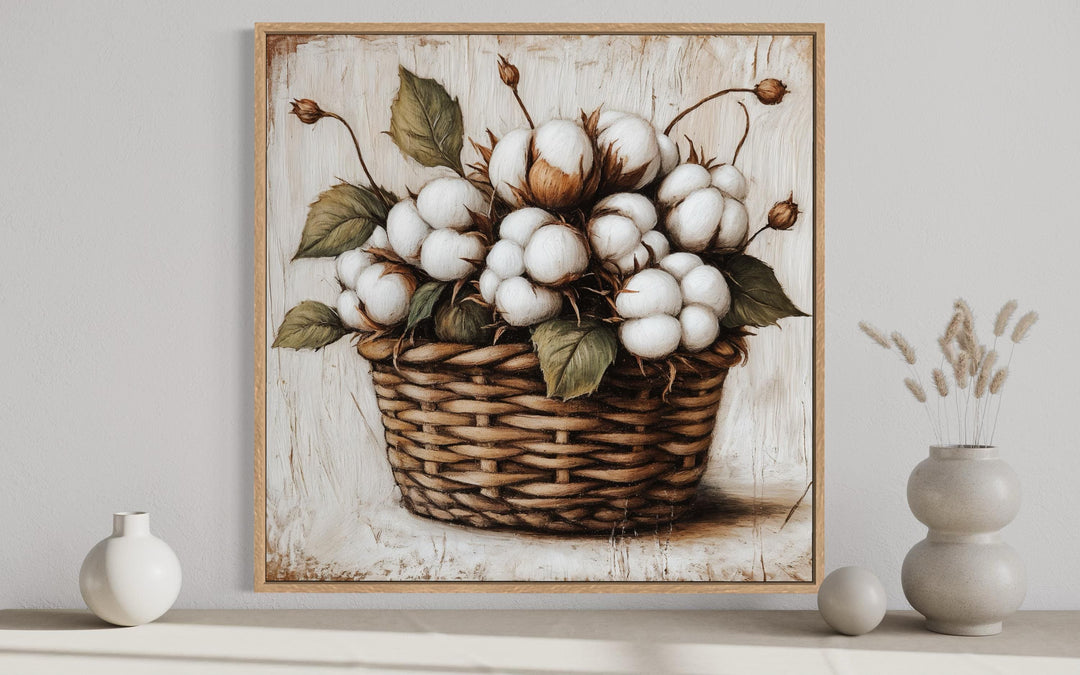Framed canvas wall art of cotton bolls in a wicker basket for rustic farmhouse decor.