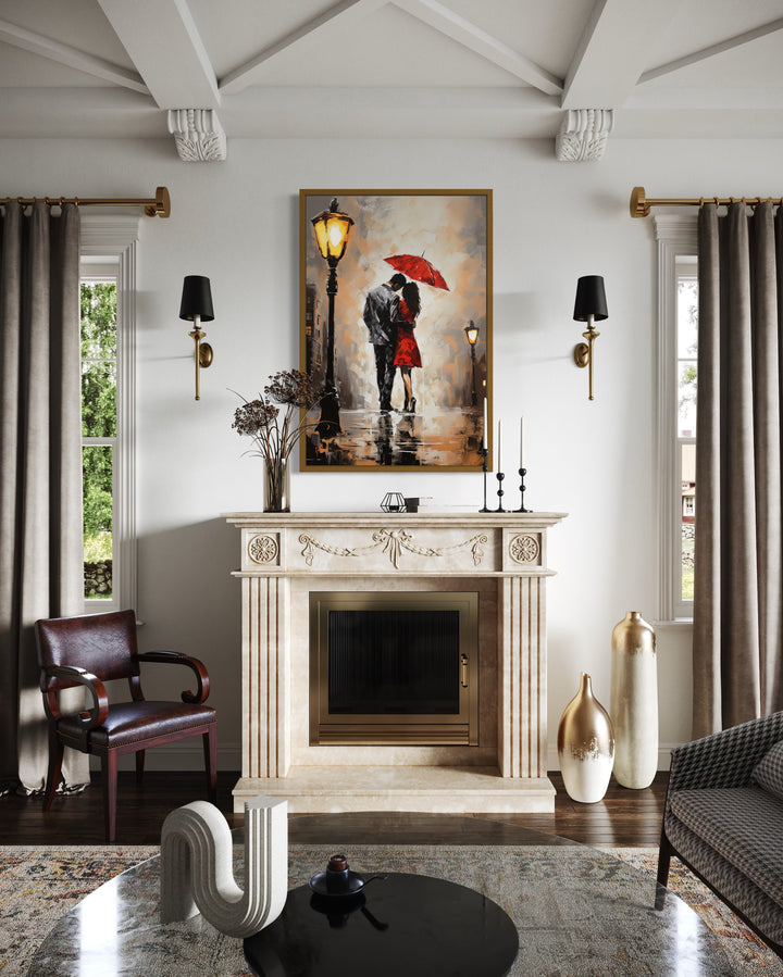 Framed canvas wall art of a couple under a red umbrella in the rain above a fireplace.
