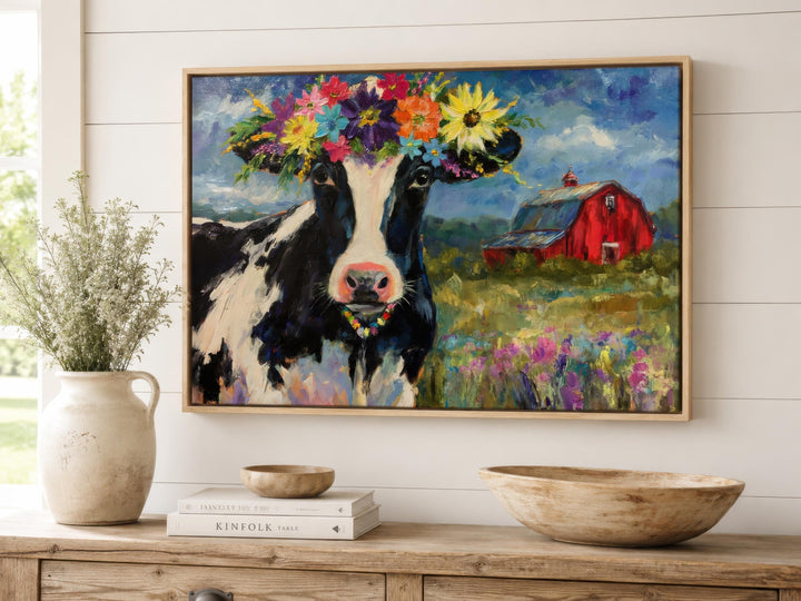Whimsical oil painting of a cow with a flower crown on a canvas, framed and hung in a farmhouse room.