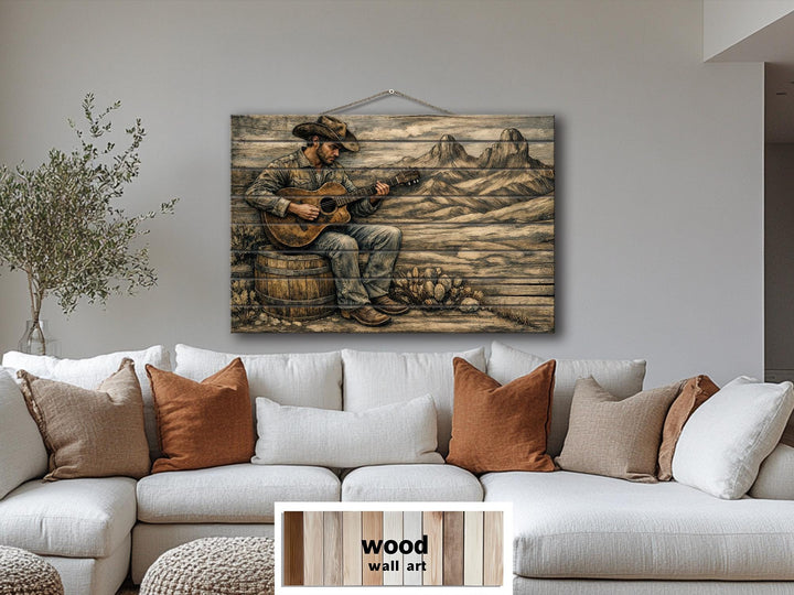 Rustic cowboy playing guitar wood wall art on a distressed panel above a white sectional sofa.